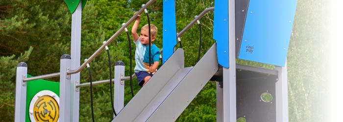 Photo of child playing on steel playground equipment