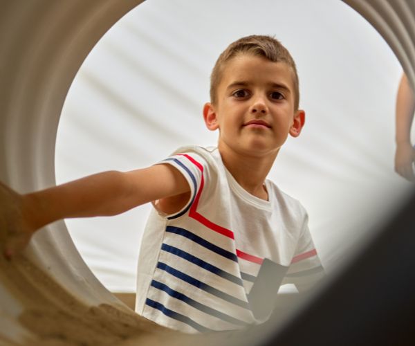 Child looking through crawl tunnel