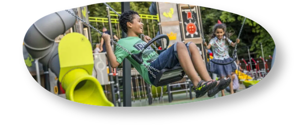 Children playing on swing sets in local playground